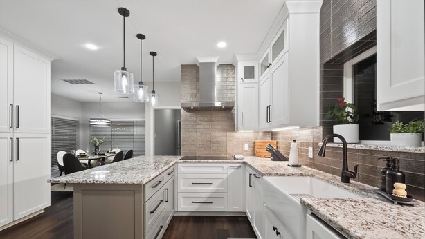 A modern kitchen with white cabinets, granite countertops, and stainless steel appliances. - Luxury Frisco Home w/Private Pool, Game Room, 85" TV, Cozy Patio & Huge Backyard (Frisco)