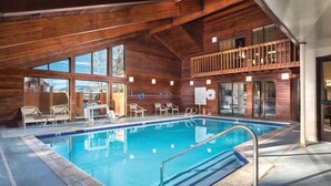 An indoor swimming pool with a wooden deck, lounge chairs, and a balcony overlooking the pool. - 3BR, sleep 8, Club Wyndham, ski shuttle, pool, spa in Steamboat Springs (Steamboat Springs)