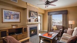 A cozy hotel room with a fireplace, comfortable seating, and a large window offering a view. - 3BR, sleep 8, Club Wyndham, ski shuttle, pool, spa in Steamboat Springs (Steamboat Springs)