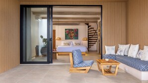 Un dormitorio moderno con una cama, una silla, un sofá, una mesa y una escalera.