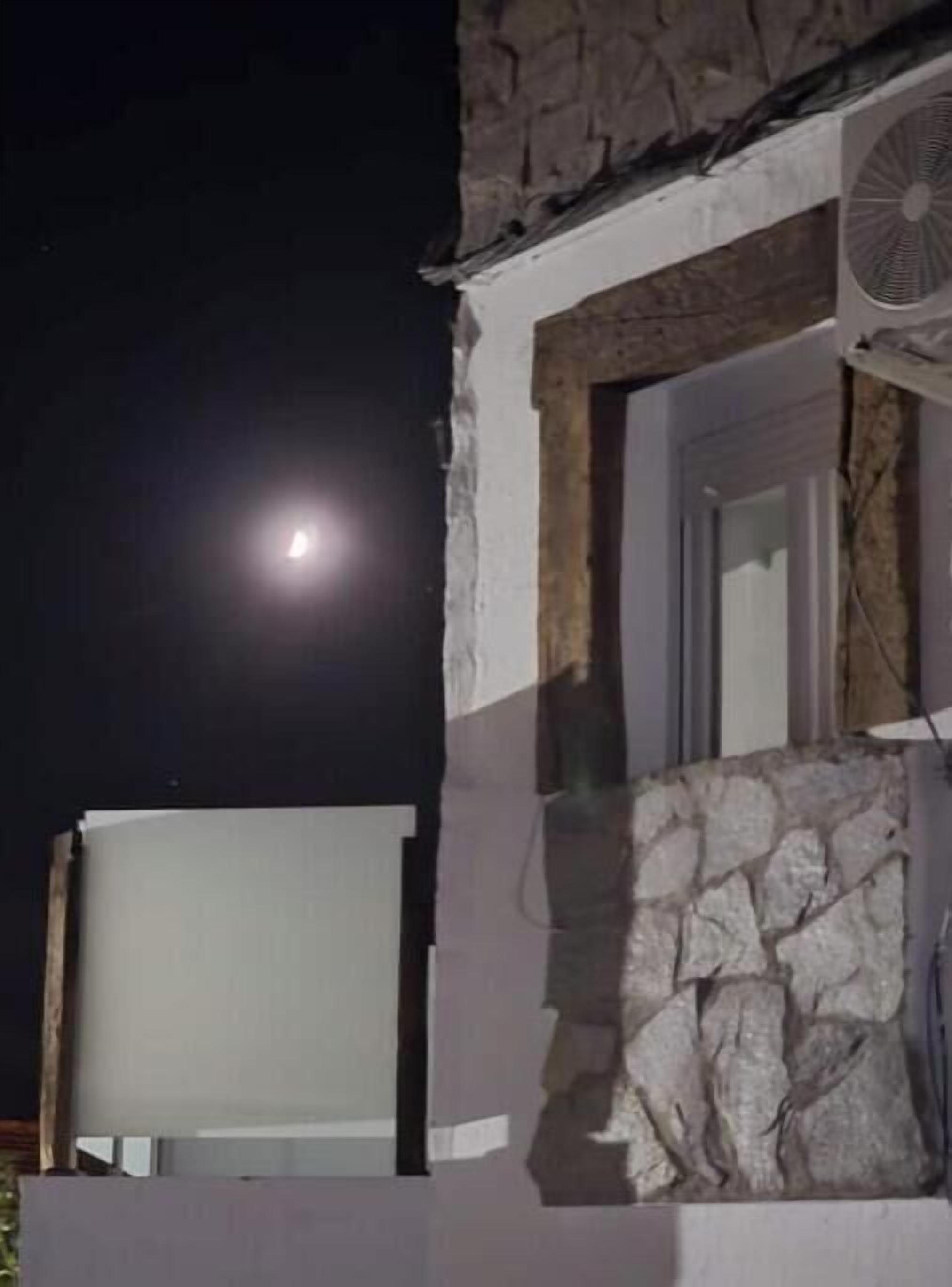 A building with a stone facade, a window, and a fan.