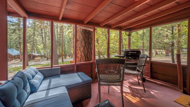 A covered outdoor seating area with a sofa, chairs, and a grill. - Outlaw Cabin - Newly Renovated, Covered Deck, Tons of Wildlife (Ruidoso)