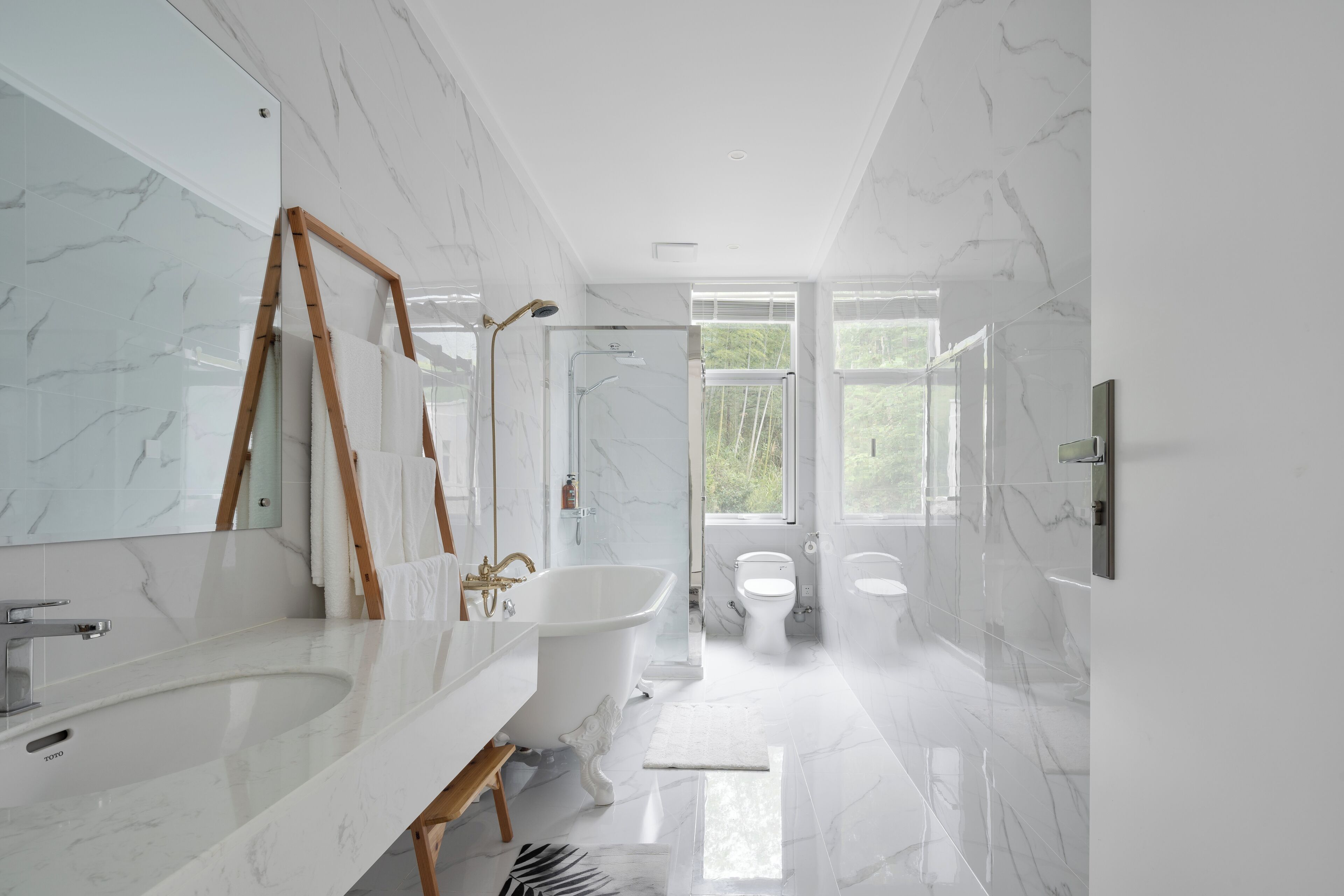A modern bathroom with a freestanding bathtub, a large mirror, and a vanity with a sink.