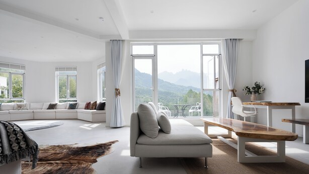 A modern living room with a large window, a sofa, a wooden bench, and a dining table. - daiyungui (Huangshan)