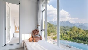 A teddy bear on a windowsill overlooking a mountain landscape. - daiyungui (Huangshan)