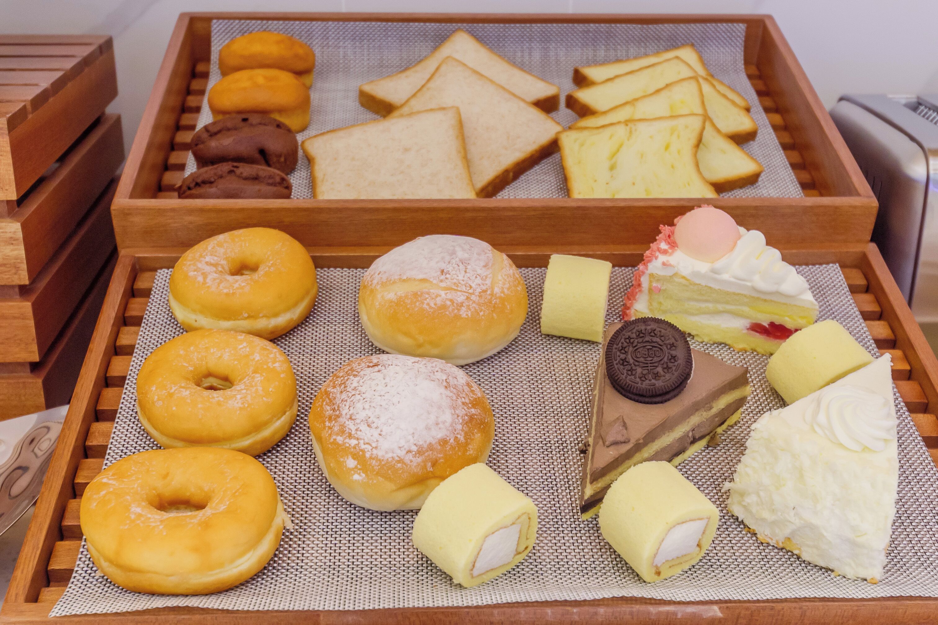 Un plateau contenant un assortiment de pâtisseries, notamment des beignets, des biscuits et des gâteaux.