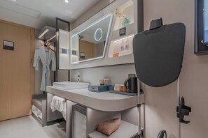 A modern bathroom with a large mirror, a sink, and a towel rack. - SKYBIRD Hotel (Hangzhou)