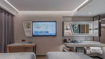 Habitació d'hotel moderna amb llit, escriptori i bany.