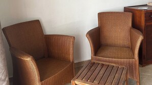 Ein Zimmer mit zwei Korbstühlen und einem Holztisch.