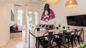 A modern kitchen with a central island, black chairs, and a large flat-screen TV on the wall. - MOT Rentals + Villa Embajada - 6 Bd pax Deluxe House Belgrano (Buenos Aires)
