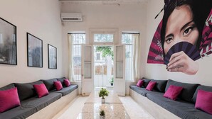 A modern hotel lobby with a central seating area, framed artwork on the walls, and a large mural. - MOT Rentals + Villa Embajada - 6 Bd pax Deluxe House Belgrano (Buenos Aires)