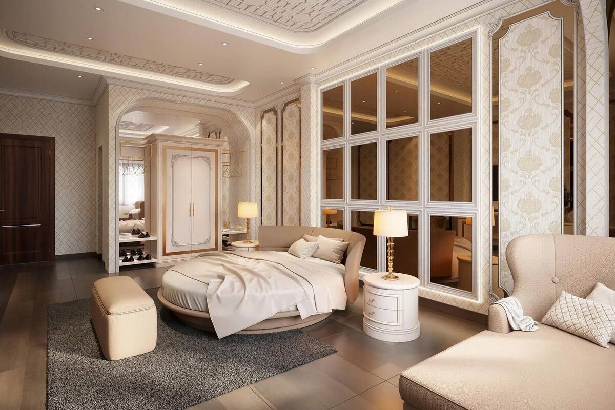 A luxurious bedroom with a large bed, a sitting area, and a wardrobe.