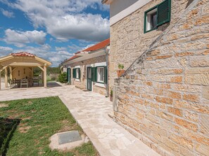 A stone building with a covered patio and a small garden area. - Rural Villa Olive Krka by Interhome (Oklaj)