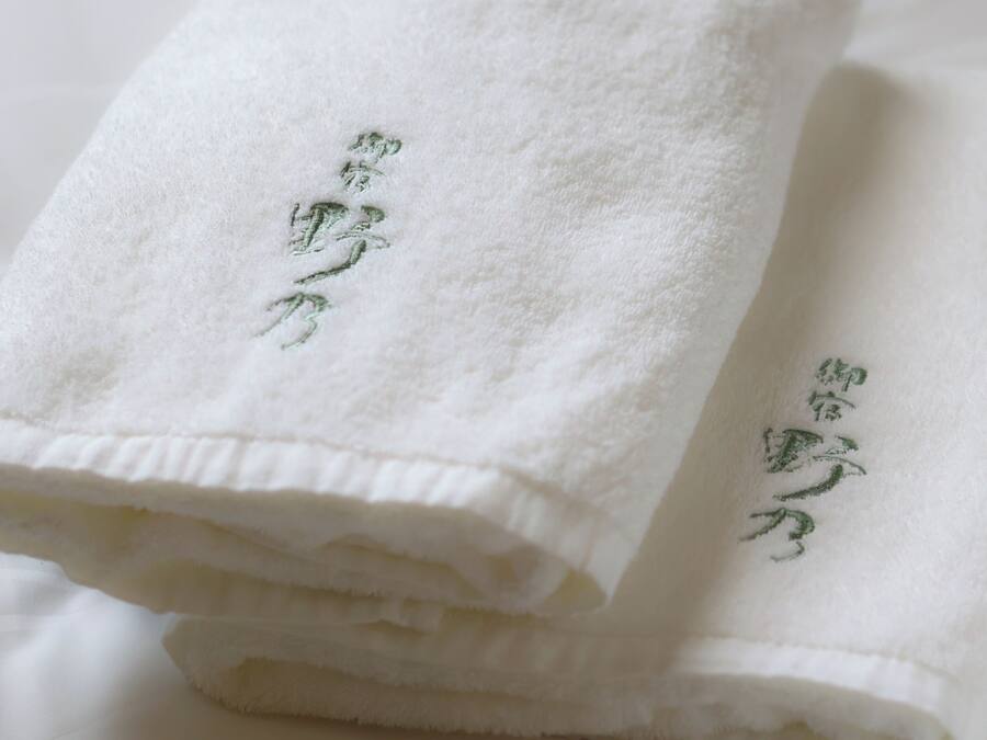 A stack of white towels with embroidered text.