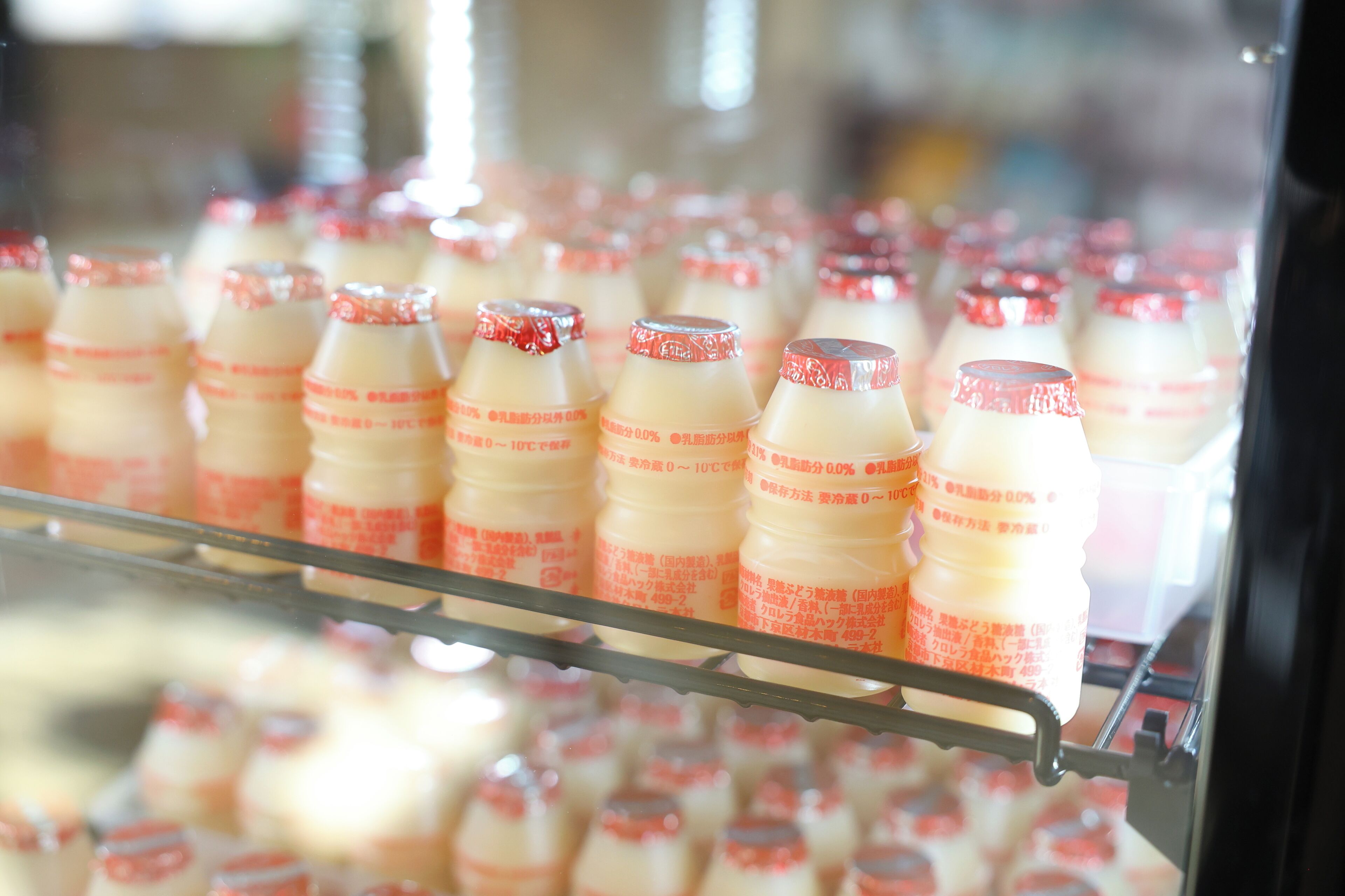 Bottles of milk in a refrigerated display.