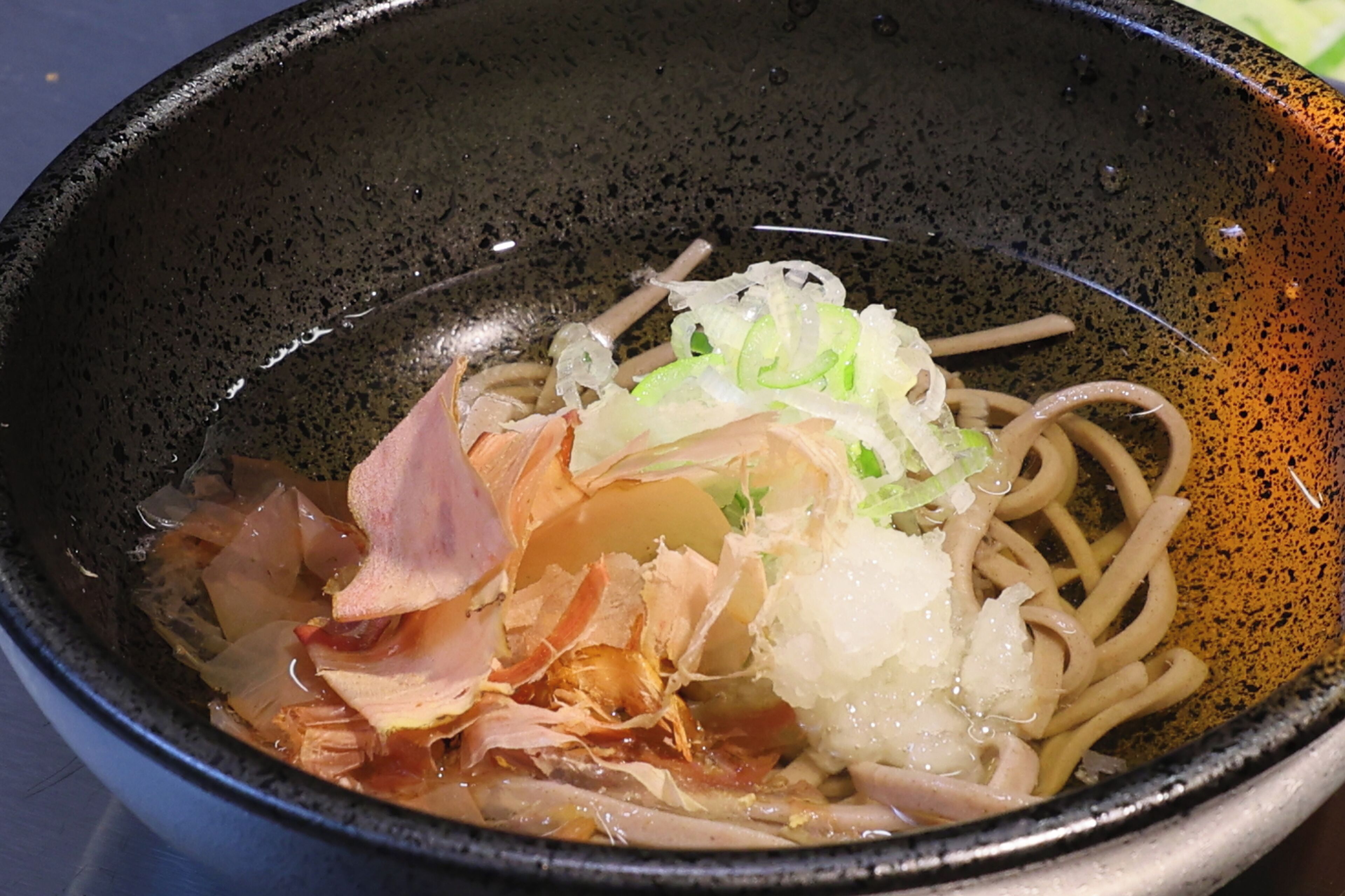 A bowl of ramen with noodles, sliced pork, seaweed, and green onions.