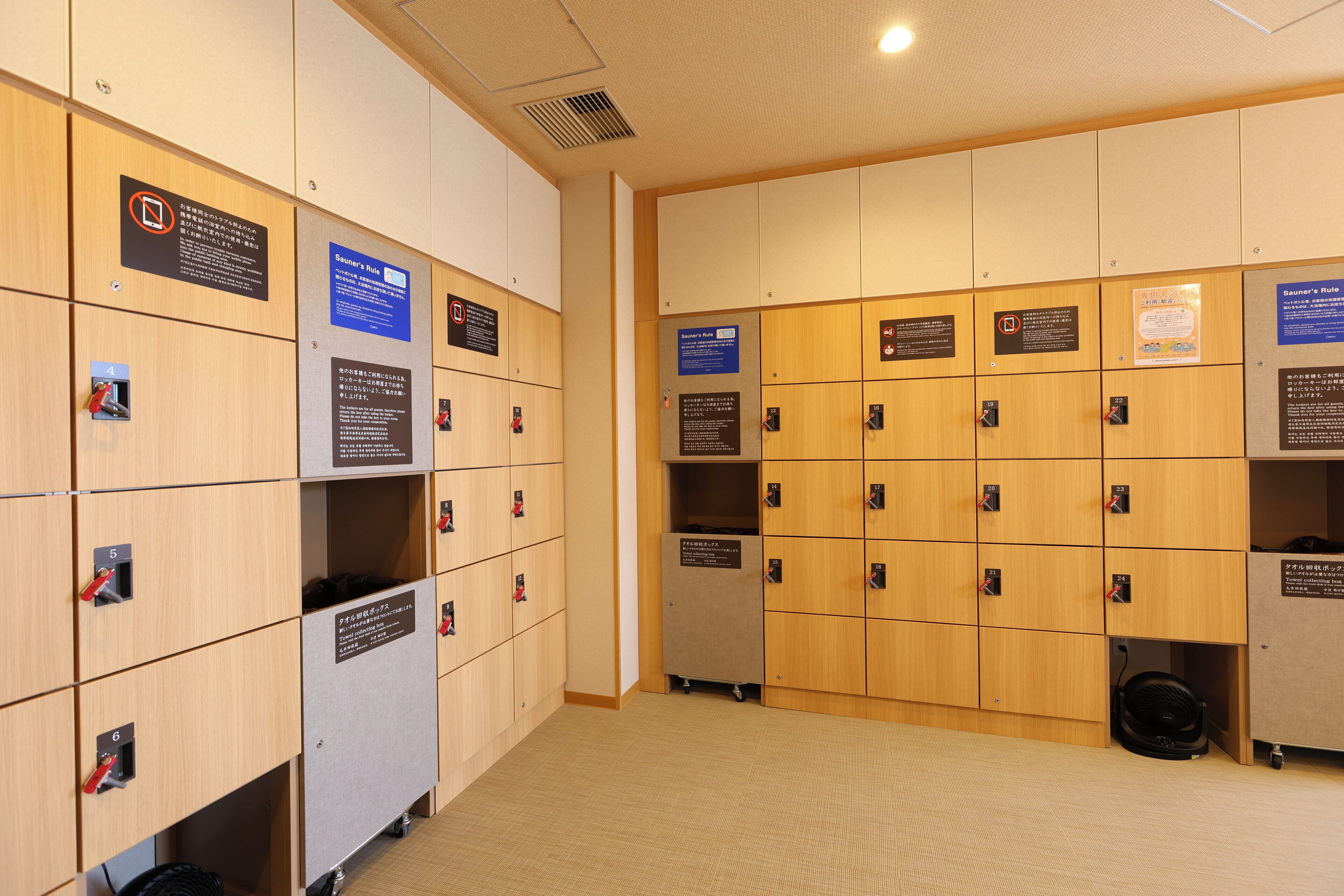 A row of wooden lockers with numbered labels and signs indicating rules.