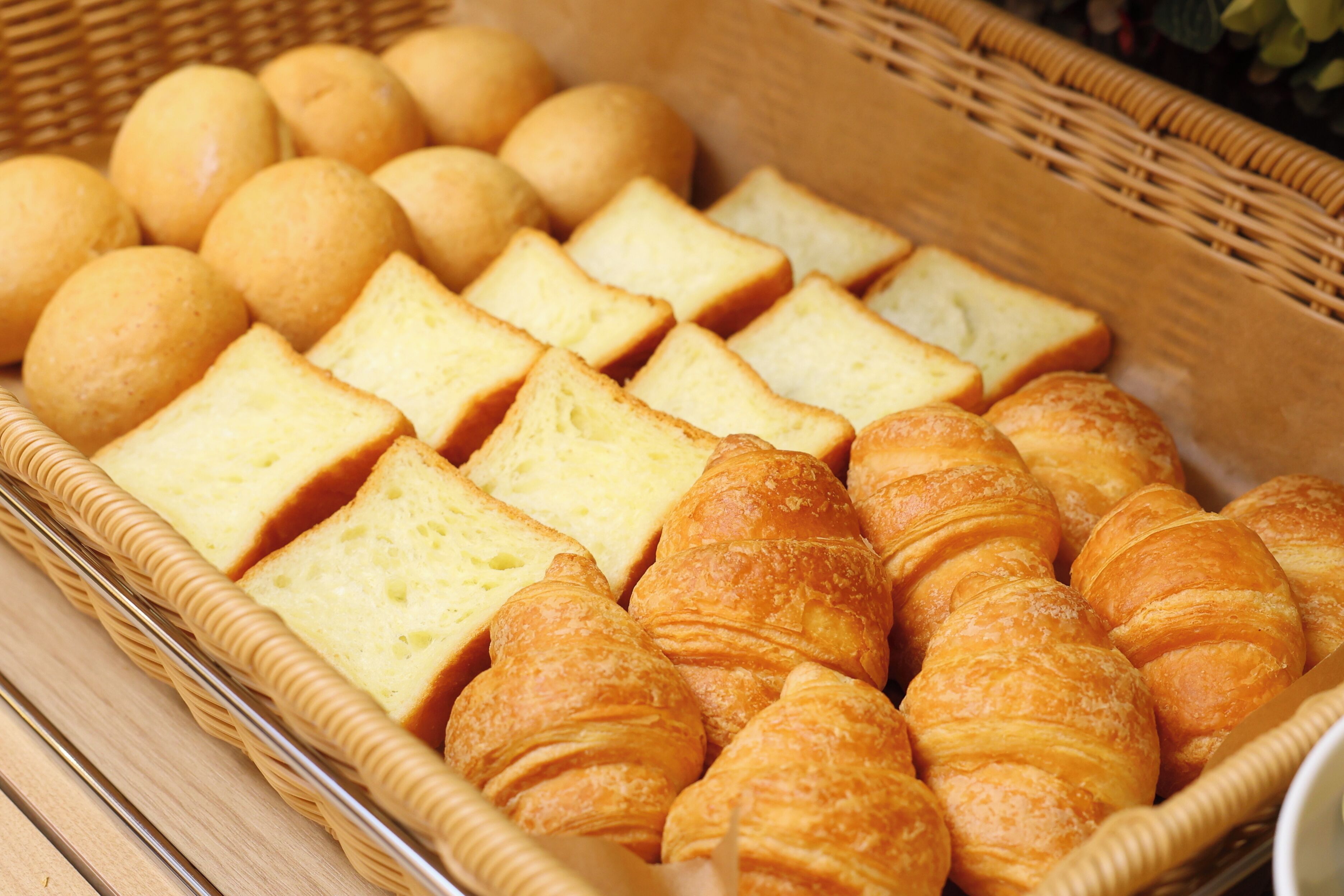 A basket containing various types of bread and pastries.