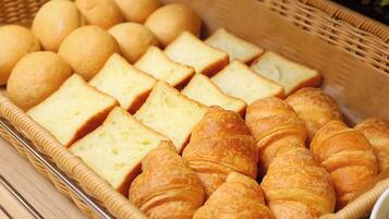A basket containing various types of bread and pastries.