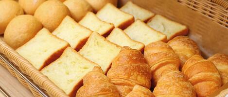 A basket containing various types of bread and pastries.