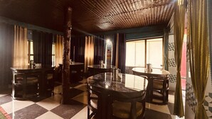 Een restaurant met geruit vloerkleed, ronde tafels en stoelen.