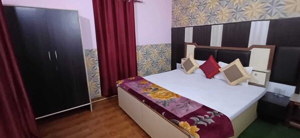 A bedroom with a bed, a wardrobe, and a patterned wall.
