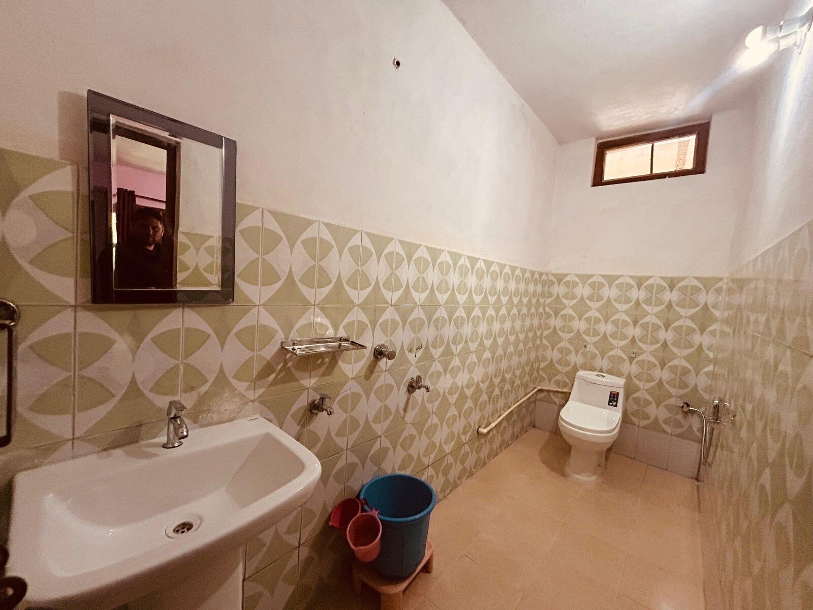 Une salle de bain avec un lavabo, des toilettes et un miroir.