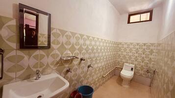 Une salle de bain avec un lavabo, des toilettes et un miroir.