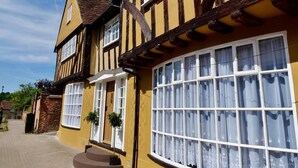A traditional half-timbered house with a prominent bay window and a small front porch. - Luxury Rock & Roll Suite in Manor House (Saffron Walden)