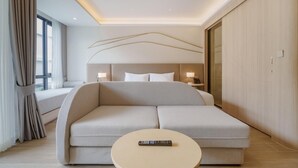 A modern hotel room with a large bed, a round coffee table, and a view of the city through large windows. - Sea Heaven Elegant Studio, Forrest View 2229 (Sakhu -  Thalang)
