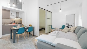 A modern apartment with a dining area, kitchenette, and a living room with a sofa and chairs. - Saro House, Centre Apartment for 6, Sanremo, Italy (Sanremo)