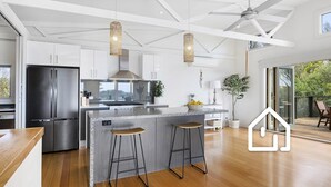 Eine moderne Küche mit einer großen Kochinsel, Edelstahlgeräten und einem Deckenventilator.