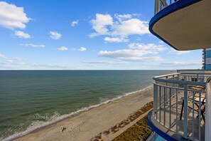 Ein Balkon direkt am Strand mit Blick auf das Meer und den Strand.