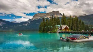 Un chalet au bord du lac, doté d’un quai, de kayaks et offrant une vue sur les montagnes.