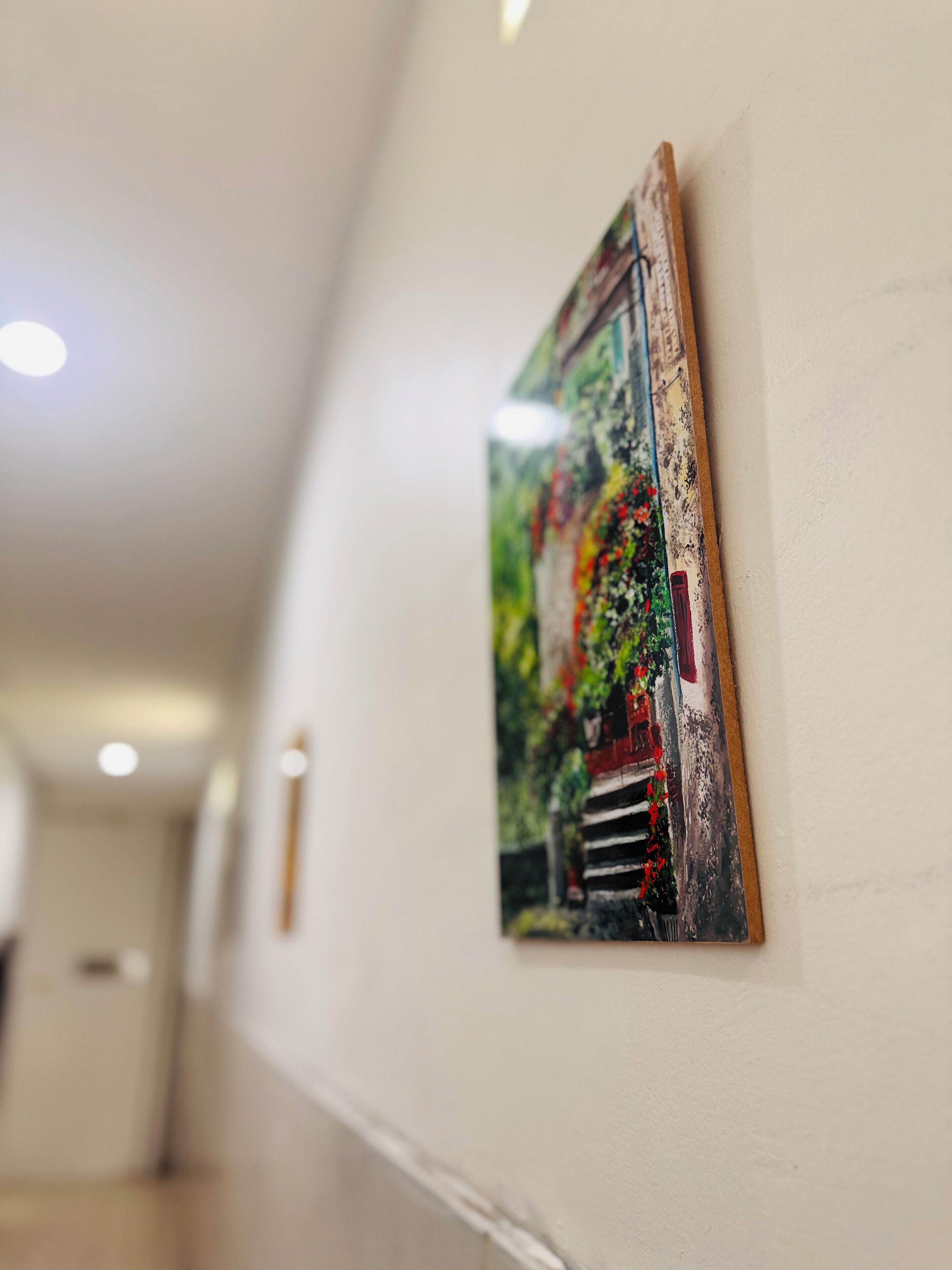 A hallway with a framed artwork on the wall.