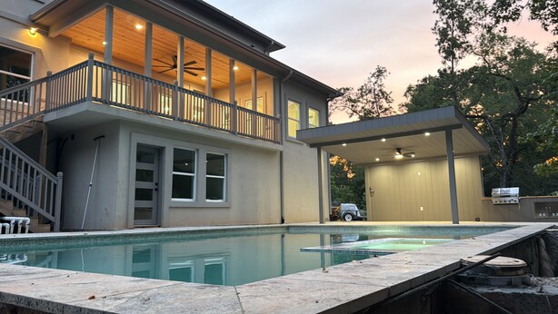 Una casa moderna con piscina, un porche cubierto y un garaje.