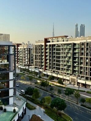 A modern high-rise building with multiple balconies and a rooftop garden. - Cozy Azizi Riviera Studio High Floor Burj Khlifa View in Dubai (Dubai)