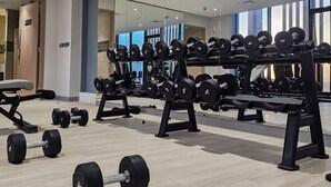 Ein modernes Fitnessstudio mit Krafttrainingsgeräten, Spiegelwänden und einem aufgeräumten, großzügigen Raum.