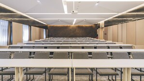 A conference room with rows of tables and chairs, a projector on the ceiling, and a large window on the left. - Echarm PLUS Hotel Chongqing  (Chongqing)