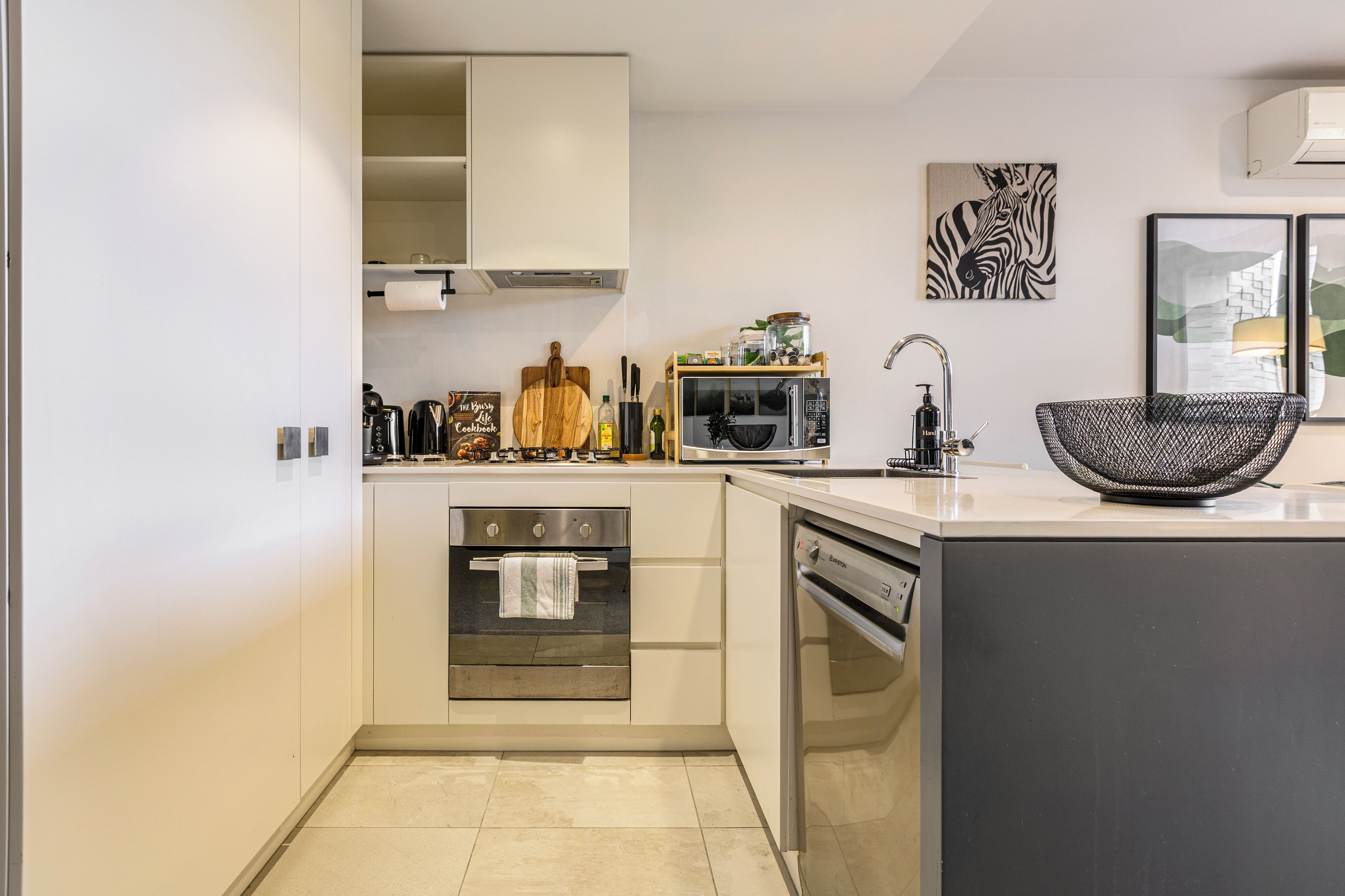 A modern kitchen with a built-in oven, a microwave, and a sink.