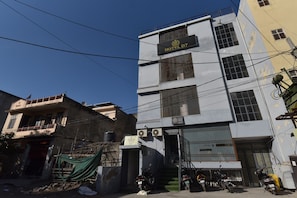 A multi-story building with a sign for HOTEL D7, a gated entrance, and parked motorcycles. - Hotel D7 (Jaipur)