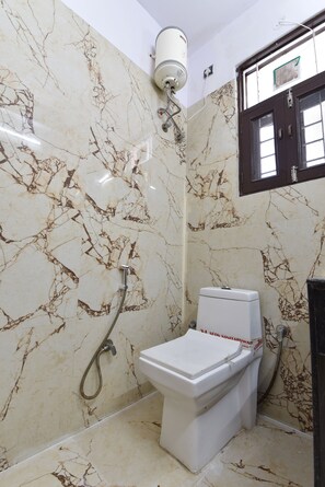 A bathroom with a toilet, shower, and a water heater. - Hotel D7 (Jaipur)