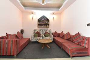 Ein Zimmer mit zwei Sofas, einem runden Tisch und einer Wanddekoration.