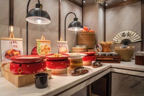 Een buffetopstelling met verschillende bakken en bestek.