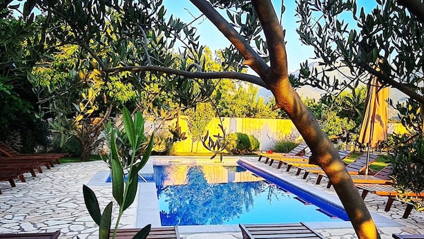 A pool area with lounge chairs and a stone patio.
