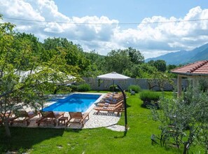 Un jardin avec une piscine, des chaises longues et une pergola.