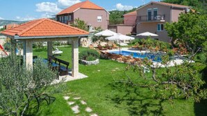 A residential area with a swimming pool, lounge chairs, and a gazebo.