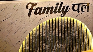 Un espace d’accueil avec un mur en bois, un panneau circulaire portant le logo « HR PALACE » et un comptoir à motifs de marbre.