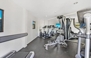 A gym with treadmills, elliptical machines, and weight equipment. - Luxe CBD Apt | Hyde Park Views + Pool & Gym & Spa (Darlinghurst)
