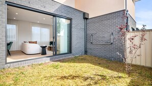Ein modernes Haus mit einer großen Schiebetür, die zu einem Wohnbereich mit Sofa und Couchtisch führt.